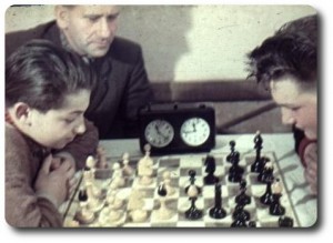 Mladí sachiste s panem Machem v pozadi.